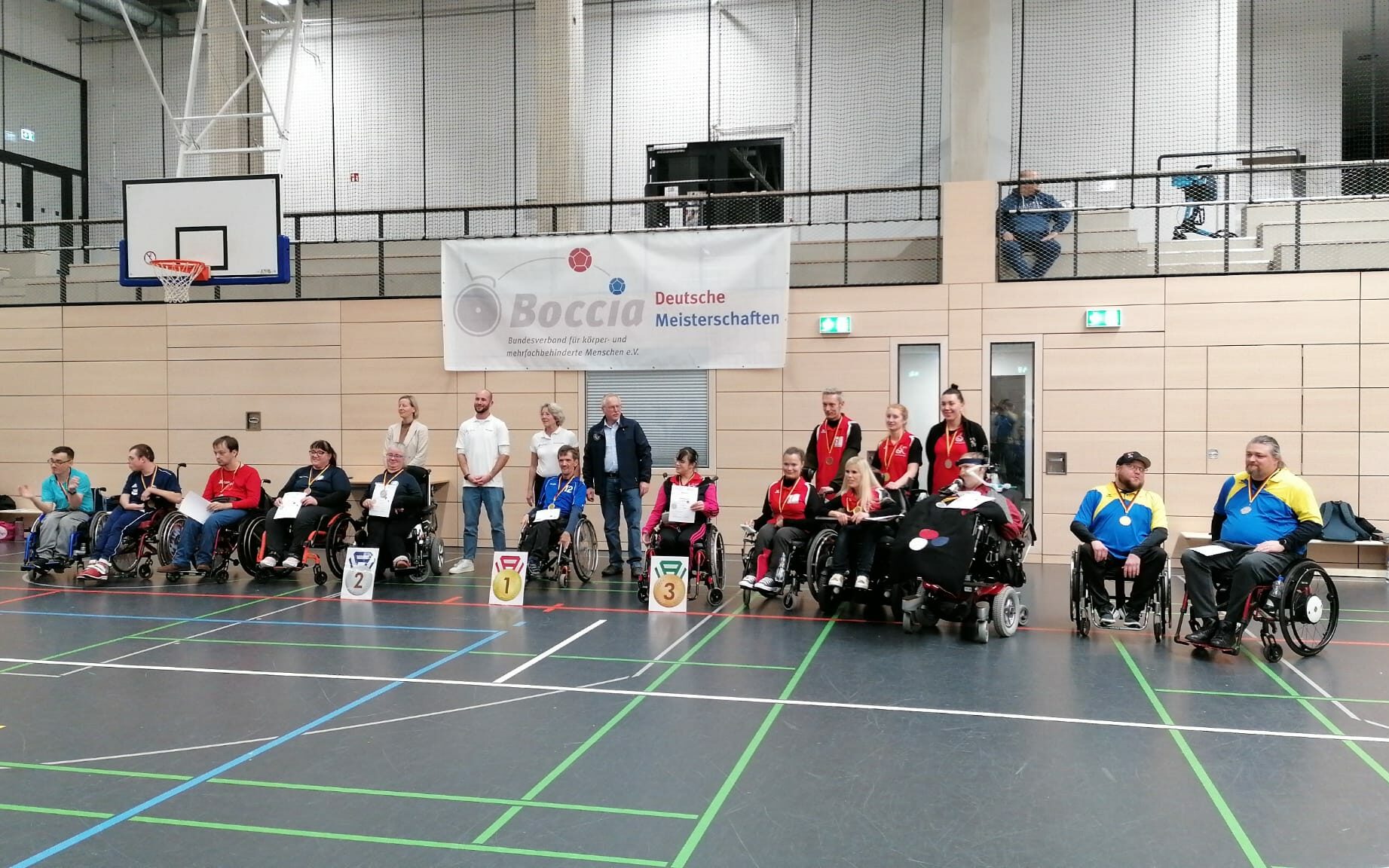 Foto der Spieler*innen auf den Podiumsplätzen der Klassen BC1 bis BC4 bei den 19. Deutschen Boccia-Meisterschaften in Düsseldorf 2023